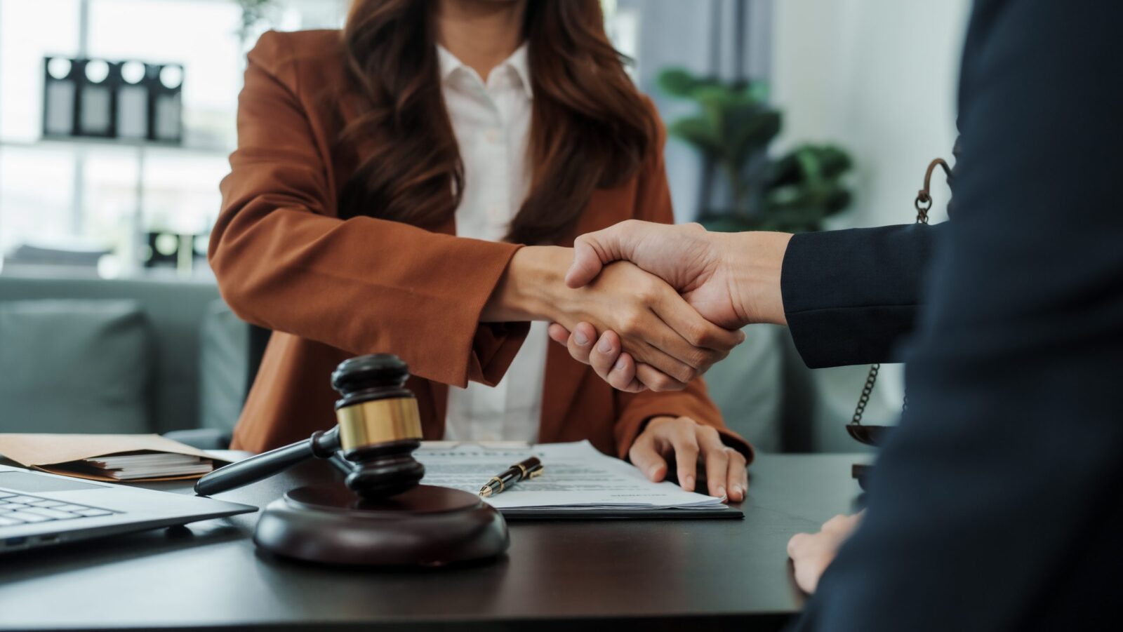 Two people shaking hands over a prenup wedding plan